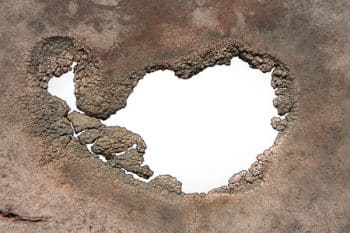 44309329 - a hole with jagged decaying edges isolated on white